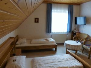 1 Schlafzimmer mit 2 Betten und einem großen Fenster in der Unterkunft Gasthaus zur Linde in Rothenburg ob der Tauber