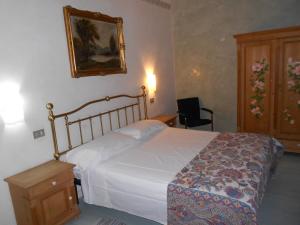 1 dormitorio con 1 cama blanca grande y armario de madera en Marta, en Trieste