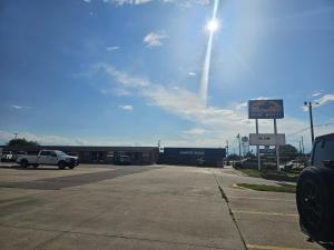 a parking lot with a building with a sign in front at Capital O Marysville Surf Motel Kansas in Marysville