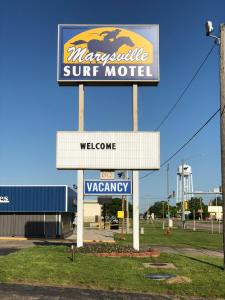 a sign for a sun motel in a parking lot at Capital O Marysville Surf Motel Kansas in Marysville