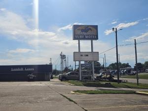 a sign for a sunoco super motel in a parking lot at Capital O Marysville Surf Motel Kansas in Marysville