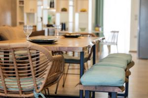 ナフパクトスにあるMy Nafpaktos Resortの椅子付きのダイニングテーブルと座席付きの木製テーブル