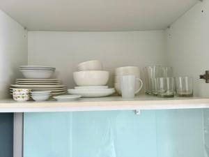 a shelf with plates and cups and other dishes at Diamond condo apart Bangtao beach in Bang Tao Beach +3 photos