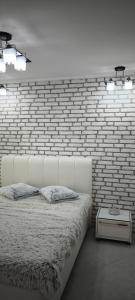 een slaapkamer met een bakstenen muur en een wit bed bij Luxury Sunrise Complex Apartment in Goudstrand +46 foto's