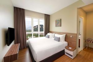 a hotel room with a bed and a large window at TUI BLUE The Haven Ipoh in Ipoh