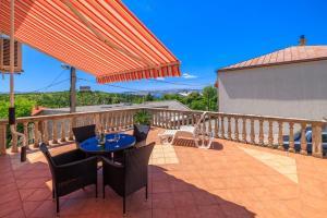 a patio with a table and chairs on a balcony at Apartments and rooms Bionda in Senj