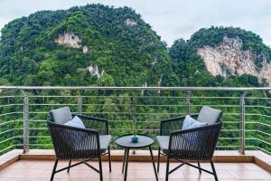 a balcony with chairs and a table and mountains at TUI BLUE The Haven Ipoh in Ipoh +59 photos
