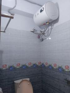 a bathroom with a toilet and a camera on the wall at Hotel Inn Chittagong in Chittagong
