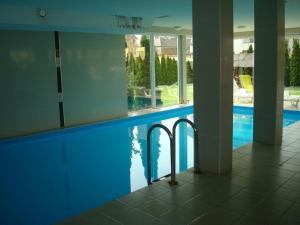 a swimming pool in a building with a reflection in the water at Honey Wellness Apartman in Siófok