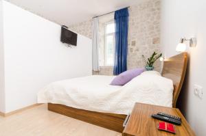 Dormitorio pequeño con cama y mesa en La Porta Heritage, en Dubrovnik