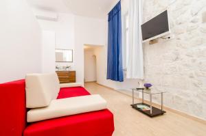 sala de estar con sofá rojo y TV en La Porta Heritage, en Dubrovnik