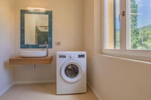a bathroom with a washing machine and a sink at Casale sul Mare - Grilli 2 in Lacona