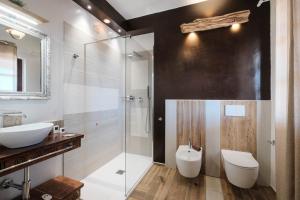 a bathroom with a sink and a toilet and a shower at RADICI DI LUNA Exclusive Design in Castelsardo