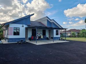 a blue and white house with a parking lot at Impian homestay, wcy in Kota Bharu