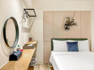 a bedroom with a bed with a mirror and a table at Flower House in Tainan