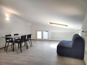 a room with a table and chairs and a couch at La mansarda del Panfilo in Cervia