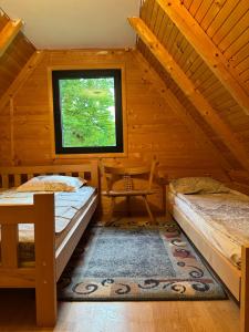 ein Schlafzimmer mit zwei Betten in einer Blockhütte in der Unterkunft Hideaway with a view in Žabljak