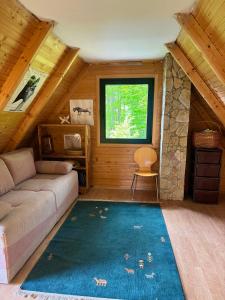 ein Wohnzimmer mit einer Couch und einem Fenster in der Unterkunft Hideaway with a view in Žabljak
