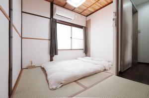 Postel nebo postele na pokoji v ubytování 西九条駅徒歩3分USJと梅田と関空直通丸々貸切一軒家koto別館