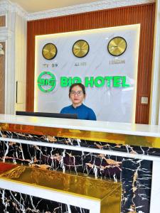 a woman standing in front of a sign for a big hotel at BIG Central Hotel Can Tho - 7 Minutes to Ninh Kieu Wharf in Can Tho +16 photos