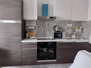 a small kitchen with a stove and a microwave at Beautiful apartment with 2 terraces and a parking space in Kaštela