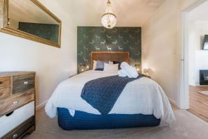 une chambre avec un grand lit et un miroir dans l'établissement Airedale Cottage, à Hanmer Springs