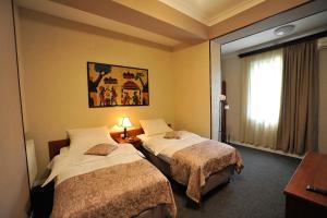 Habitación de hotel con 2 camas y ventana en ZP Hotel, en Tiflis