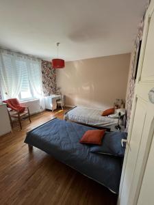 ein Schlafzimmer mit 2 Betten und einem Stuhl darin in der Unterkunft La Couade de Troche in Troche