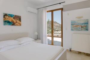 Postel nebo postele na pokoji v ubytování Manolioudis Villas + 37 fotografií