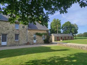 an old stone house with a grass yard at Chambre d'hôte à la Gilardière in Châtelain