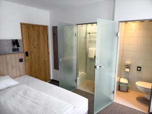 sypialnia z łóżkiem, prysznicem i toaletą w obiekcie Hotel Anker w mieście Klosterneuburg