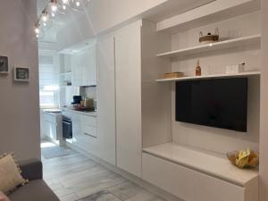 a white kitchen with a flat screen tv on a wall at Casa Letizia Pescara Centro in Pescara