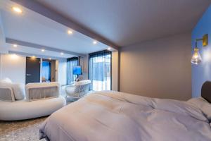 a bedroom with a large white bed and a living room at awaJ Beach Club アワジェイビーチクラブ in Awaji +106 photos