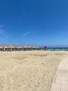 a sandy beach with umbrellas and the ocean at Casa Letizia Pescara Centro in Pescara