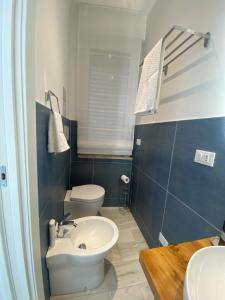 a bathroom with a white toilet and a sink at Casa Letizia Pescara Centro in Pescara