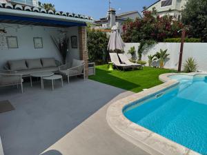 a backyard with a swimming pool and a couch and a table at Casa Estrella Gandia in Gandía