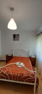a bedroom with a large bed with a light above it at Casa do Vale in Arcos de Valdevez