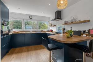 cocina con armarios azules y encimera de madera en Seaside Rendezvous - Sleeps 7, Sea Views & Parking, en Brixham