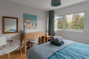 Un dormitorio con una cama, un escritorio y una silla. en Seaside Rendezvous - Sleeps 7, Sea Views & Parking, en Brixham