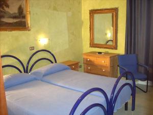 um quarto com uma cama, uma cómoda e um espelho em Marta em Trieste