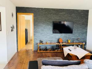 a living room with a couch and a tv on a wall at Haus-Elena-Wohnung-7B in Bestwig