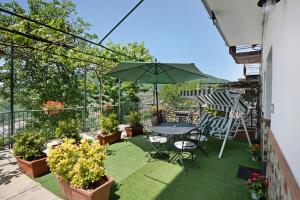 un patio con tavolo, sedie e ombrellone di Bella veduta Luna ad Agerola