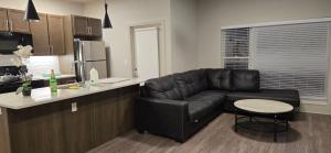 sala de estar con sofá de cuero negro en la cocina en Furnished Executive 3-bed 2-bath Apartment Wichita Kansas, en Wichita