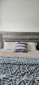 una cama con cabecero de madera y dos almohadas en Furnished Executive 3-bed 2-bath Apartment Wichita Kansas, en Wichita
