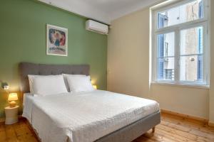 um quarto com uma cama branca e uma janela em Grand Haven - New Renovated Spacious Apts in Prime Location em Atenas