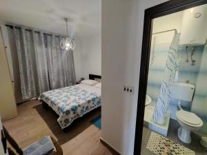 a small bedroom with a bed and a toilet at Apartments Stana in Sukošan +25 photos