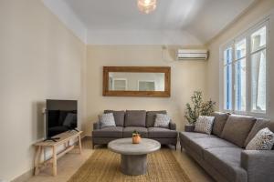 uma sala de estar com um sofá e uma TV em Grand Haven - New Renovated Spacious Apts in Prime Location em Atenas