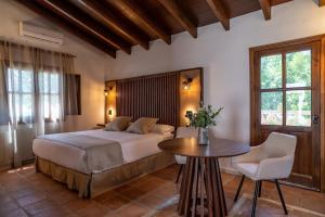a bedroom with a bed and a table and chairs at Málaga Sierra de las Nieves by Real Spain Hotels Adults Recommended in Casarabonela +127 photos