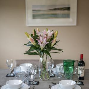 een tafel met een vaas met roze bloemen erop bij Muirton Cottage in Ardovie