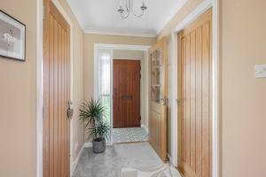 een hal met een houten deur en een potplant bij Muirton Cottage in Ardovie +18 foto's